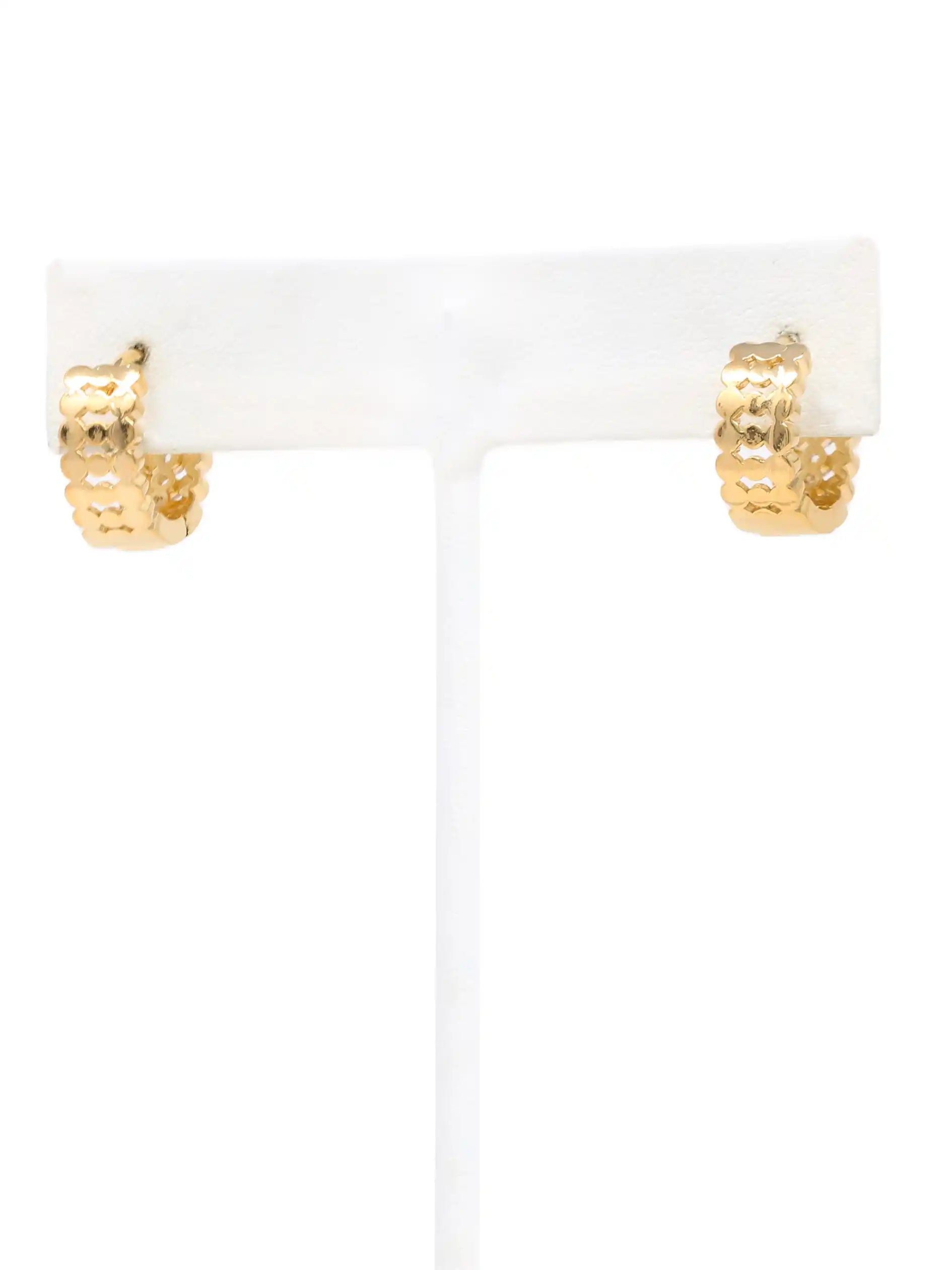 A pair of small gold hoop earrings with a textured, honeycomb-like pattern, displayed on a white T-stand against a white background.