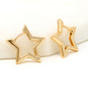 A pair of modern star huggie earrings in gold.