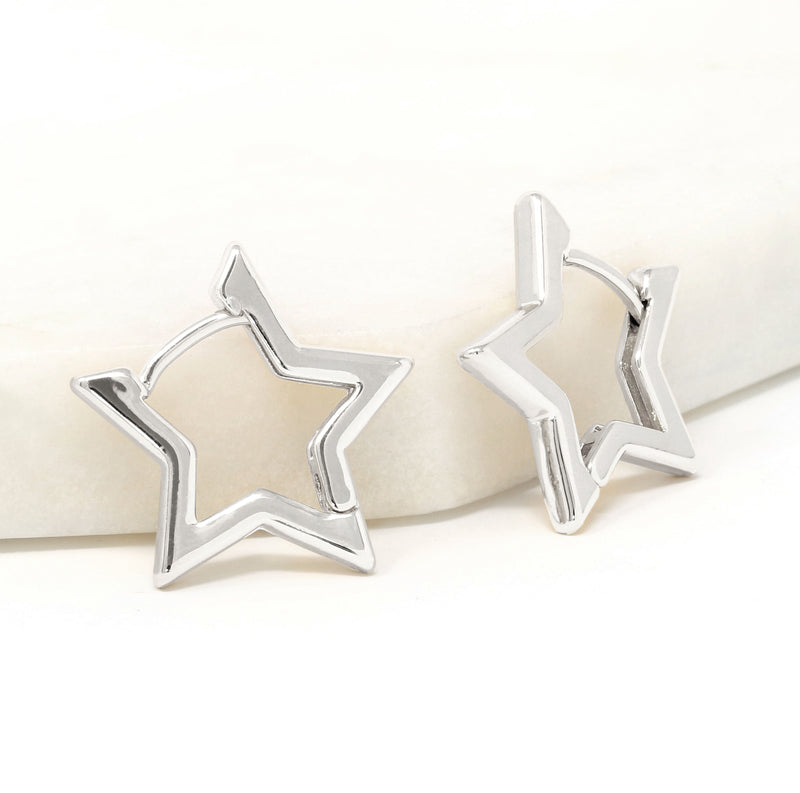 A pair of modern star huggie earrings in silver.