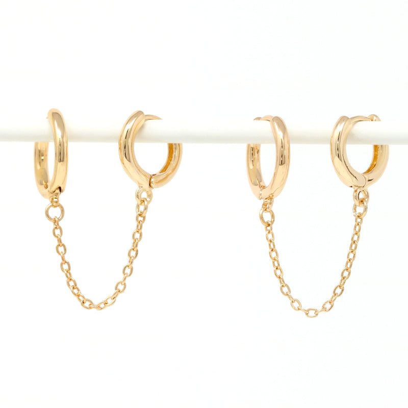 Modern loop earplug earrings in gold, connected with chains.