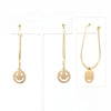 A pair of smiley face charmed teardrop hoop earrings in gold.