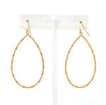 A pair of lightweight teardrop-shaped metal statement earrings. The surface of the earrings is textured, creating a reflective and eye-catching effect. The earrings have a simple and modern design, yet stylish.