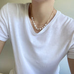 Wearing a double Layered Freshwater Pearl Necklace Set In Gold.