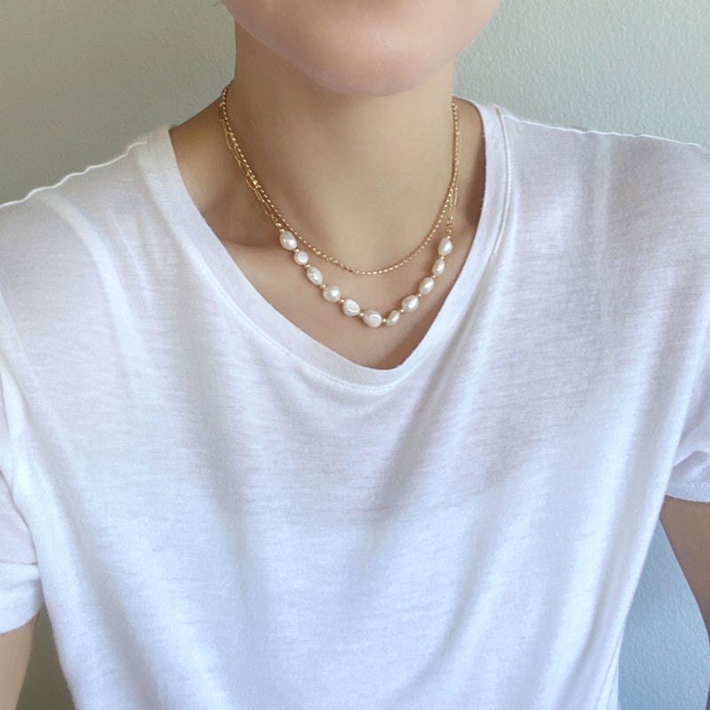 Wearing a double Layered Freshwater Pearl Necklace Set In Gold.