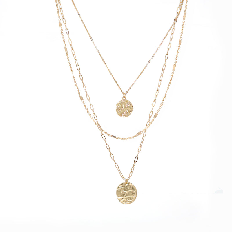 This simple yet stylish necklace in gold consists of three layers of metallic chains, adorned with dangling charms. The chains include a fine cable chain, a textured chain, and a paperclip chain, giving the necklace a modern and versatile look.