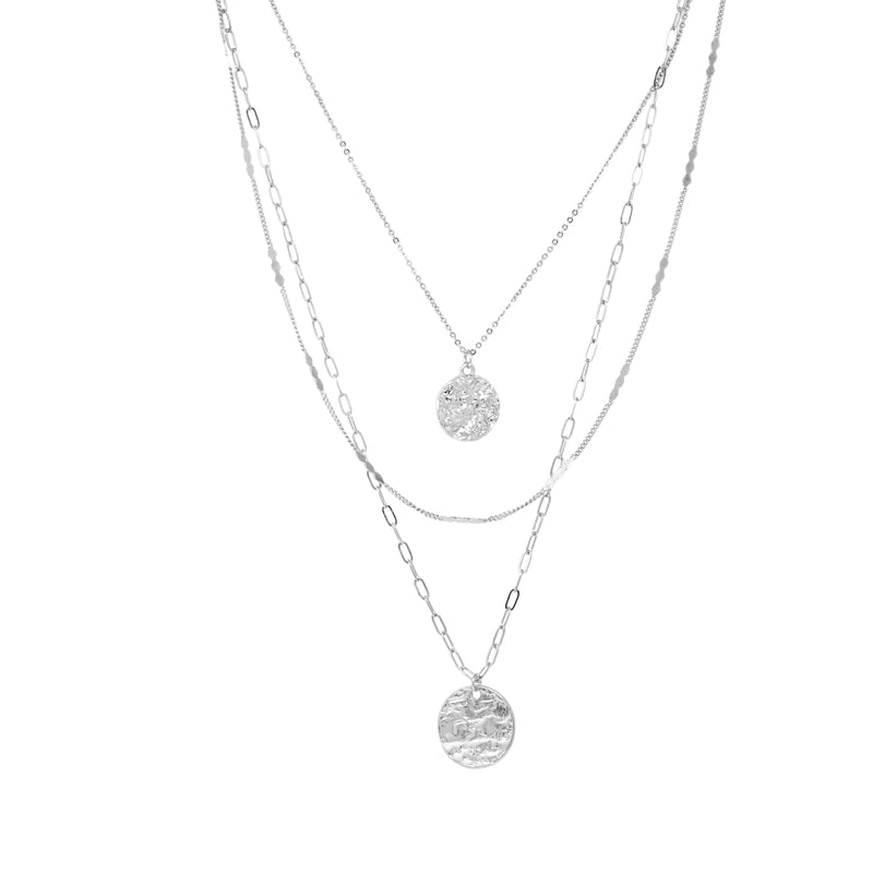This simple yet stylish necklace in silver consists of three layers of metallic chains, adorned with dangling charms. The chains include a fine cable chain, a textured chain, and a paperclip chain, giving the necklace a modern and versatile look.