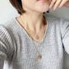 Wearing of 3 layered necklace set in gold with 2 small hammered circle charms.