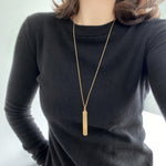 A simple bar pendant long necklace in gold.