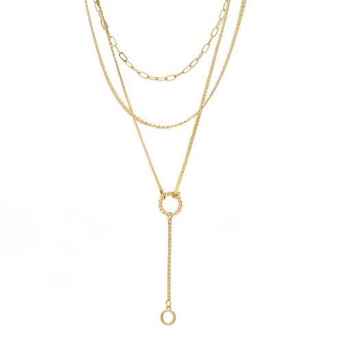 A modern triple layered necklace set in gold with a small ring charm.
