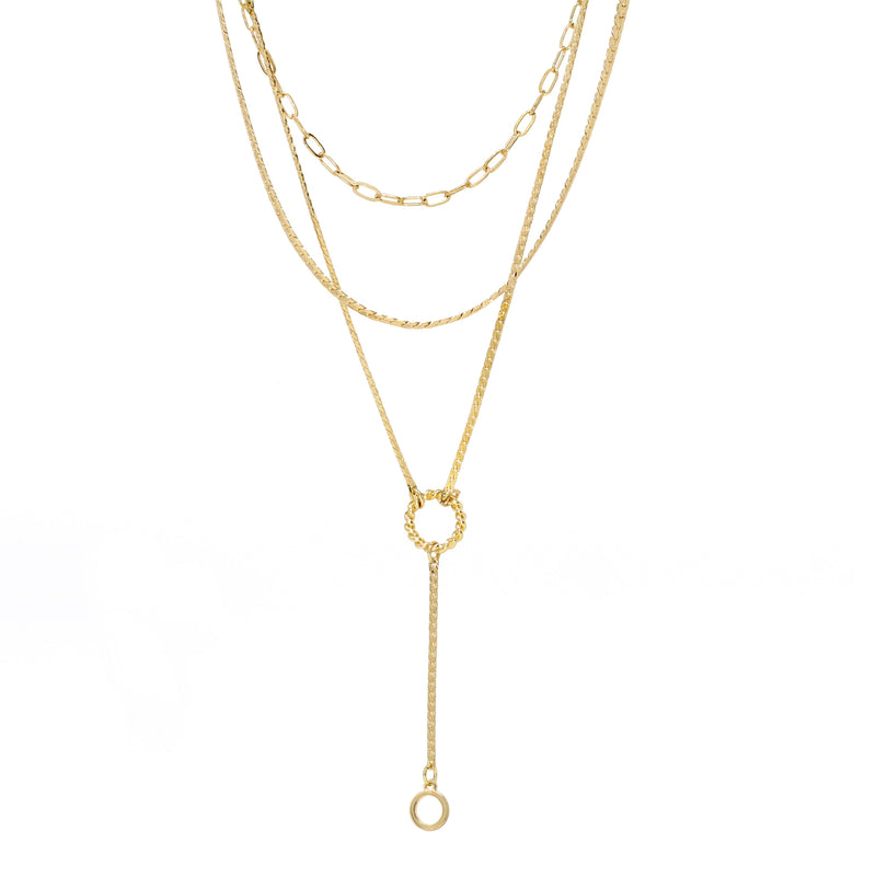 A modern triple layered necklace set in gold with a small ring charm.