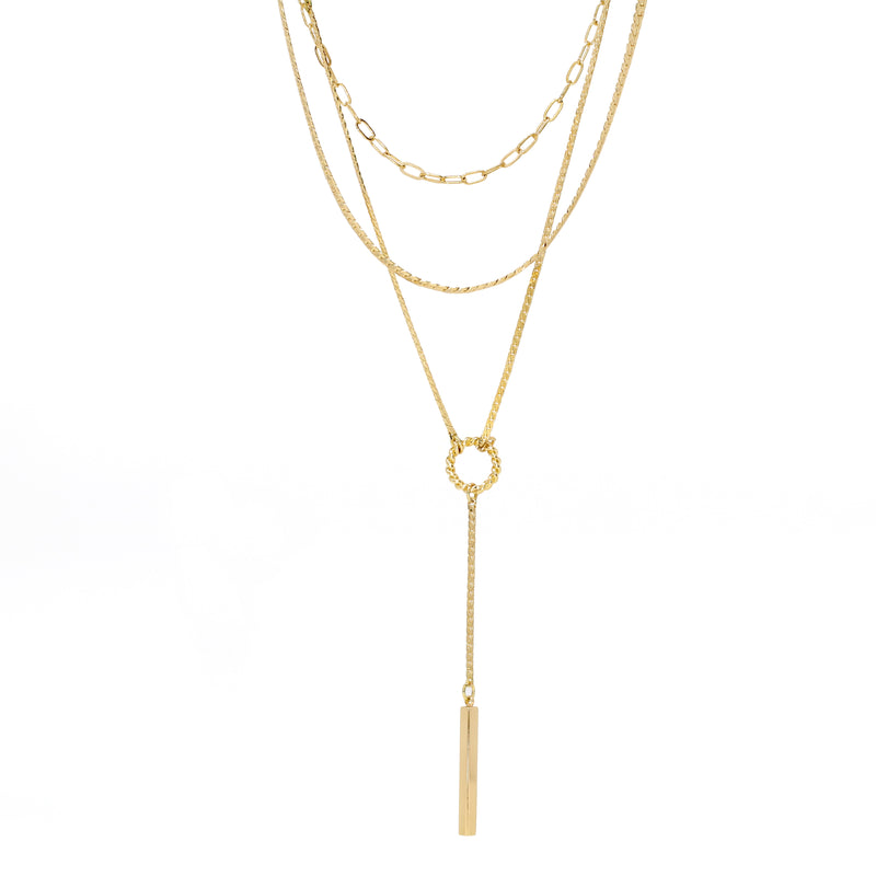 A modern triple layered necklace set in gold with a skinny bar charm.