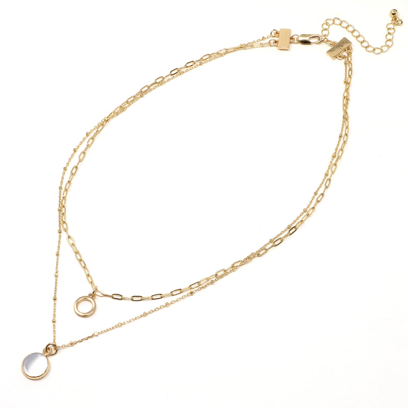 A set of double layer necklace in gold with a small disc and a gold trimmed mother of pearl charm.