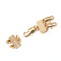 A detangler clasp in gold for a double layered or a multiple layered necklace.